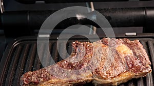 Juicy piece of beef steak on a grill seasoned with spices