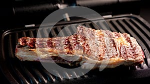 Juicy piece of beef steak on a grill seasoned with spices