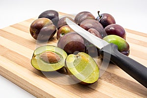 Juicy plum cuted in half on wooden board photo