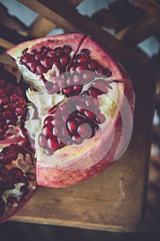 Juicy pomegranate fruit on a wooden suport.