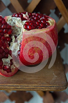 Juicy pomegranate fruit on a wooden suport.