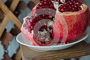 Juicy pomegranate fruit on a wooden suport.