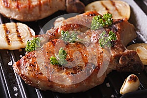 Juicy pork steak grilled with onions in a pan grill closeup