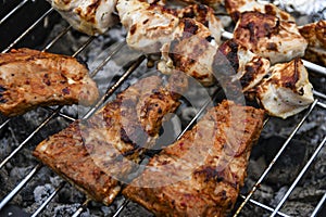 Juicy Pork steak, ribs and chicken meat on bbq grill, homemade barbecue, closeup