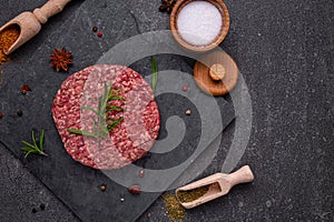 Juicy raw burger patty against a dark backdrop