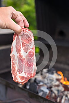 Juicy raw steak on barbecue background outdoor