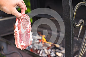 Juicy raw steak on barbecue background outdoor