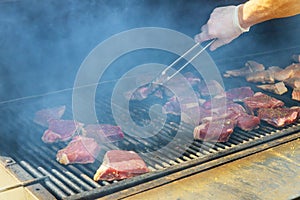 Juicy raw steaks grilling beef steak on the grill