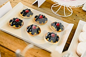 Juicy red fruits prepared on puff pastry tarts and on puff pastry tartlets