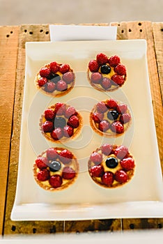 Juicy red fruits prepared on puff pastry tarts and on puff pastry tartlets