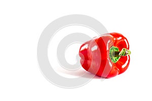 Juicy red pepper with a green tail lies on a white background