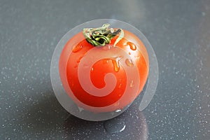 Juicy red tomato on grey background.