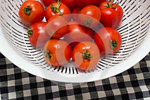 Juicy red tomatoes in table cloth . caro background photo