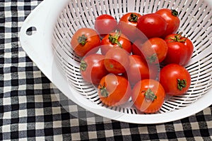 Juicy red tomatoes in table cloth . caro background photo