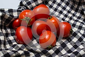 Juicy red tomatoes in table cloth . caro background photo