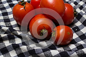 Juicy red tomatoes in table cloth . caro background photo