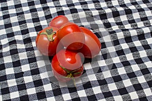 Juicy red tomatoes in table cloth . caro background photo