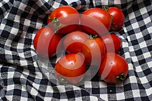 Juicy red tomatoes in table cloth . caro background photo