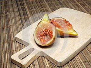 Juicy ripe figs on a cutting board. Halves of figs. Southern fruits on the table. Sliced purple fruits