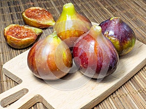 Ð¼Juicy ripe figs on a cutting board. Halves of figs. Southern fruits on the table. Sliced purple fruits