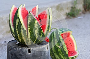 Juicy ripe watermelon cut in the shape of a flower on a street m
