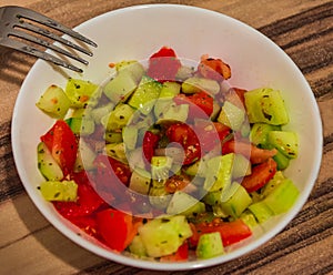 Juicy salad of tomatoes and cucumbers in a white bowl