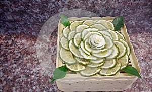 Juicy slice Makrut or Kaffir lime with green Bergamot on wood table