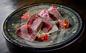 Juicy sliced steak medium rare beef in plate on wooden table