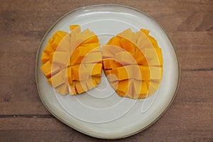 Juicy slices mango isolated on a plate on a wooden background. Healthy food menu tropical and exotic fruits. Copy space. Banner,