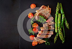 Juicy steak medium rare beef with spices and tomatoes, asparagus.