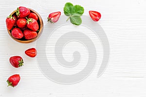 Juicy strawberry with leaves in bowl, top view