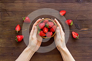 Juicy strawberry with leaves in bowl, top view