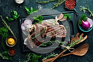 Juicy striploin steak grilled with spices and rosemary. On a black concrete background.