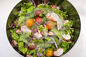 Juicy summer salad with fresh herbs, cherry tomatoes, squid and red onion. Healthy nutrition and weight loss