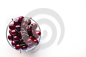 Juicy sweet cherries in a glass bowl, isolated on a white background with space for text