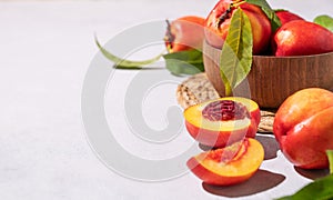 Juicy and sweet nectarines in a bowl on a light background with shadow. Healthy organic farm fruit concept