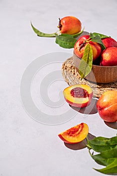 Juicy and sweet nectarines in a bowl on a light background with shadow. Healthy organic farm fruit concept