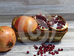 Juicy sweet ripe yellow red summer autumn pomegranate fruit on bleached oak wood background. Pomegranate seeds.