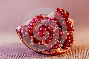 Juicy sweet slice pomegranate on fabric background