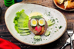 Juicy tasty meat fried cutlets with hot mashed potatoes, green lettuce leaves, on a white plate with cutlery