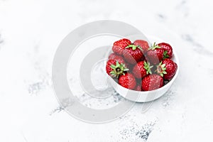 Juicy tasty strawberries in a white plate on the table