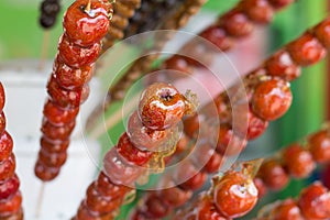 Jujubes on a stick coating in sugar. A Chinese snack dessert