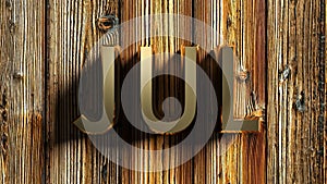 JUL brass write on raw wooden background - 3D rendering