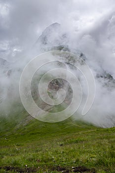 Julian Alps mountain Mangart from Mangrt saddle, Slovenia\'s Highest Panoramic Road, foggy weather