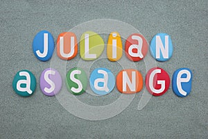 Julian Assange, Australian activist celebrated with a composition of multi colored stone letters over green sand