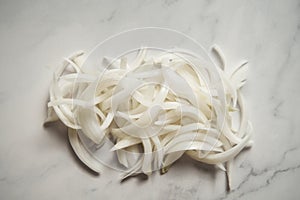 Julienne cuted onions on white marble background. Photo show how does julienne sliced or pole to pole to root to stem or