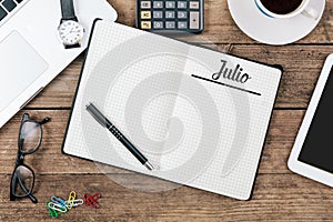 Julio Spanish July month name on paper note pad at office desk photo