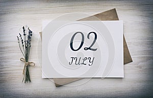 july 02. 02th day of the month, calendar date.White blank of paper with a brown envelope, dry bouquet of lavender