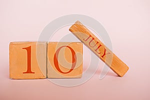 july 10th. Day 10 of month, handmade wood calendar  on modern color background. summer month, day of the year concept