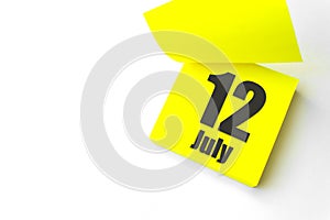 July 12nd. Day 12 of month, Calendar date. Close-Up Blank Yellow paper reminder sticky note on White Background. Summer month, day